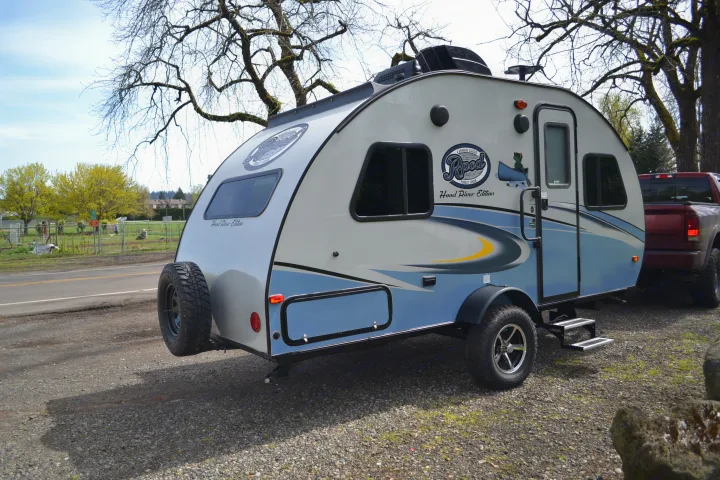 Explore with this Rpod Hood River Edition travel trailer, a top RV rental choice, parked outdoors with a truck nearby.. R-Pod R177 2018