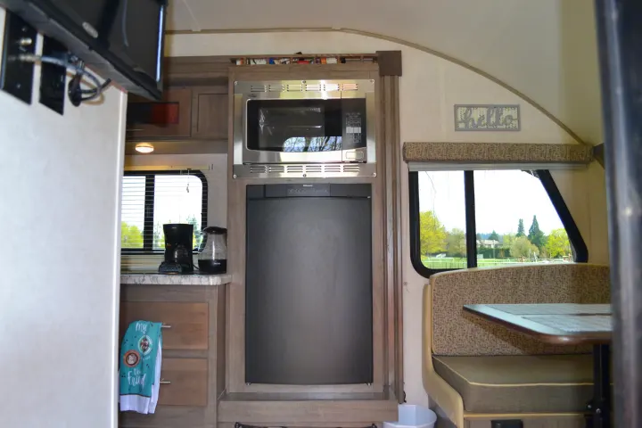This rv rental offers a well-equipped kitchen with microwave and fridge, plus a cozy dinette perfect for meals and scenic views.. R-Pod R177 2018