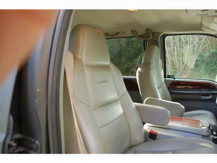 Spacious RV rental interior featuring light leather seats and wood trim, providing comfort for your journey.. Adventurer F350 2006