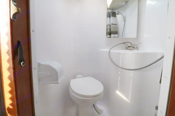 This RV rental features a compact wet bath with a toilet, sink/shower combo, and mirror, maximizing space efficiency.. Adventurer F350 2006