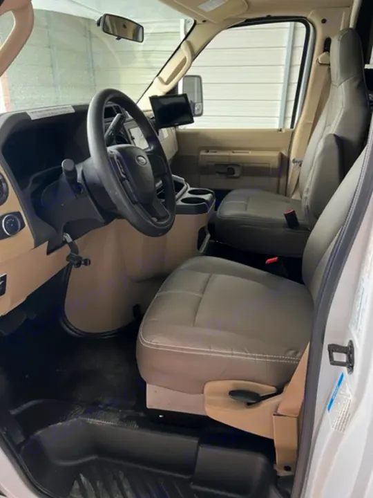 Spacious RV rental cabin interior: driver & passenger seats, steering wheel. Clean, ready for your next adventure.. Thor Quantum 2022