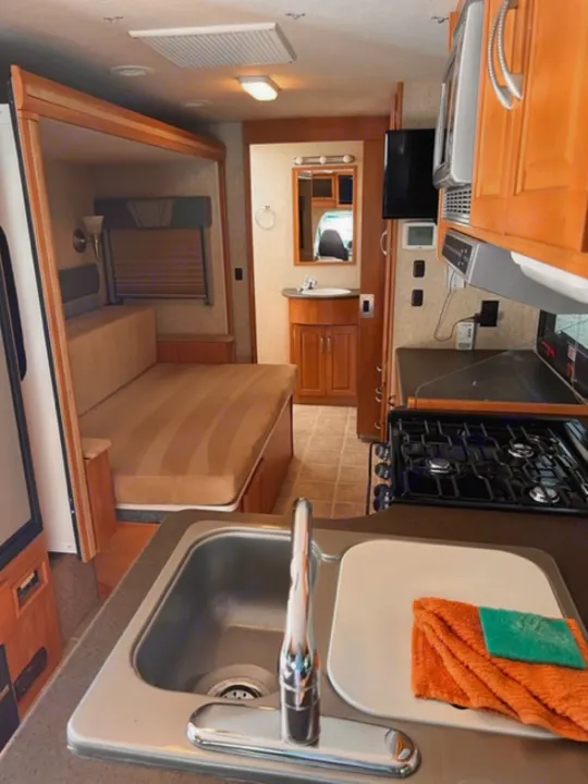 This RV rental offers a well-equipped kitchen (sink, stove, microwave), a living area with TV, and cozy sleeping space.. Itasca Cambria 2008