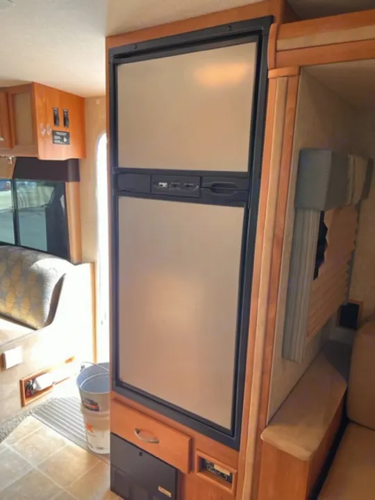 RV rental interior shows a large two-door fridge, convertible bed, and ample storage for your journey.. Itasca Cambria 2008