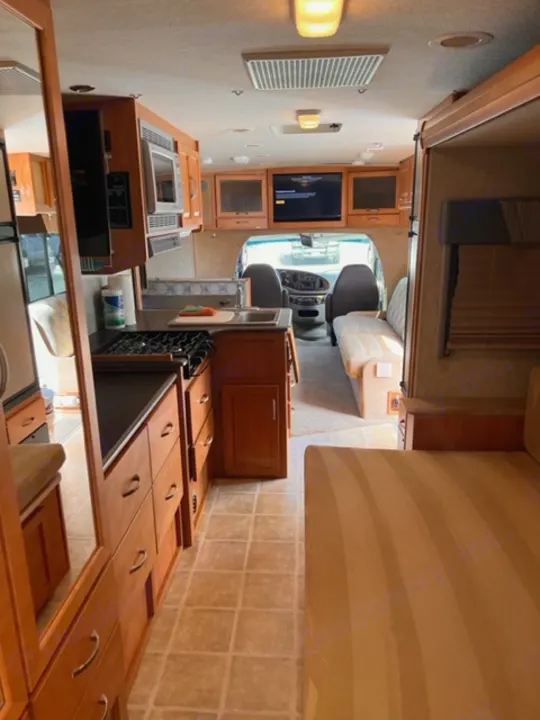 Spacious RV rental interior featuring a full kitchen, living area, and cockpit view. Perfect for your next adventure!. Itasca Cambria 2008