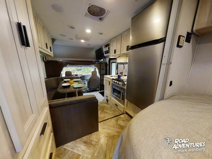 Spacious RV rental interior with kitchen, dining, and bedroom areas. Perfect for compact travel adventures.. Forest River Sunseeker 2023