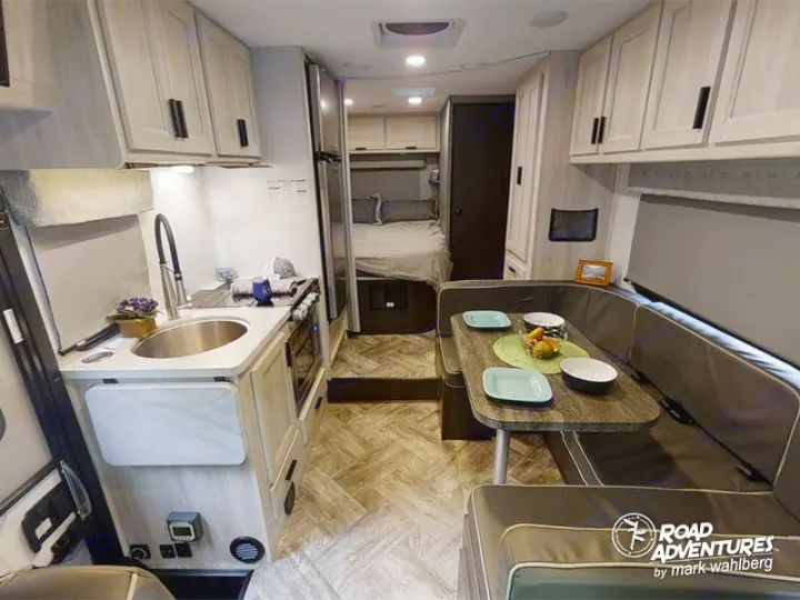 Spacious RV rental interior with a well-equipped kitchen, cozy dinette, and rear bed.. Forest River Sunseeker 2023