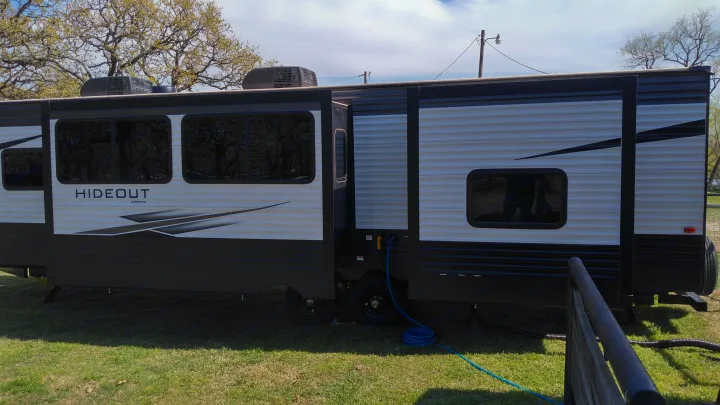 Spacious Keystone Hideout RV rental with extended slide-out at a sunny campsite, ready for adventure.. Keystone Hideout 2021