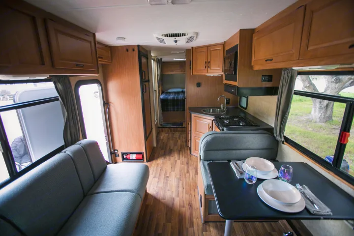 Explore this comfortable rv rental: a full interior view with kitchen, dining, sofa, and private bedroom setup.. Thor Motor Coach Four Winds Majestic 2017
