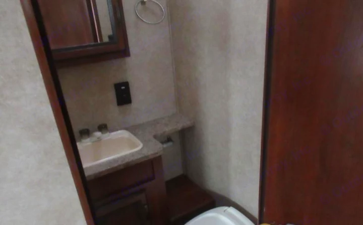 This RV rental features a compact bathroom with a sink, vanity, wall mirror, and toilet, maximizing space efficiency.. Crossroads RV Zinger 2015