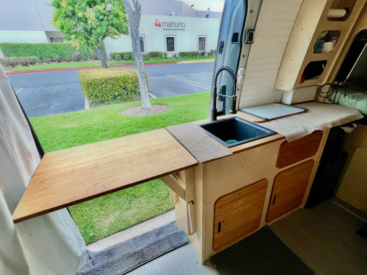 Inside this RV rental, a compact kitchen with sink and extendable counter opens to an outdoor view, perfect for mobile adventures.. Mercedes-benz Sprinter 2016