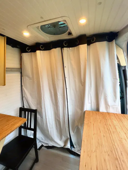 Clean RV rental interior: white paneled ceiling with fan & lights, dividing privacy curtains, and bamboo tables.. Mercedes-benz Sprinter 2016