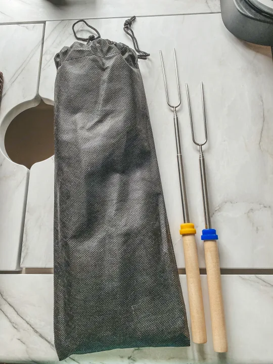 Two metal roasting sticks with wooden handles and a storage bag, essential for your RV rental campfire s'mores.. Forest River Other 2022