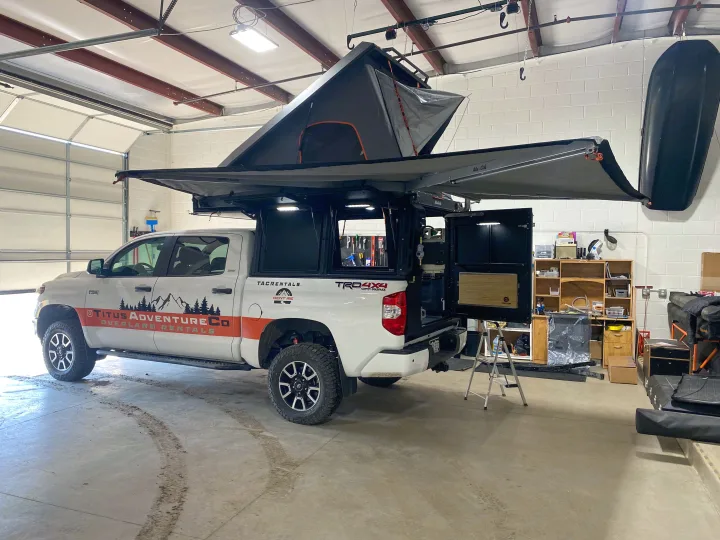 Explore off-grid with this white Toyota Tundra, a fully-equipped **RV rental** overland truck featuring a rooftop tent and camper.. Toyota Tundra 2021