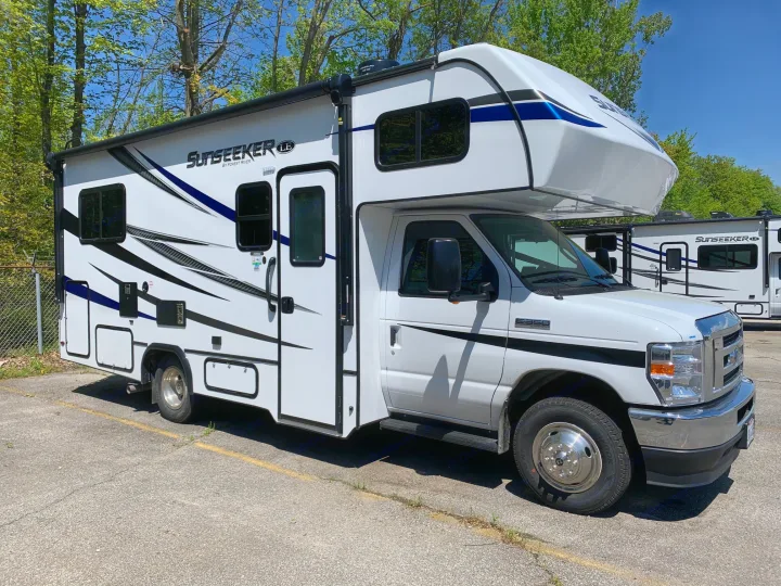 This white Sunseeker Class C RV, an excellent rv rental option, is parked on asphalt, ready for your next motorhome adventure.. Forest River Sunseeker 2023