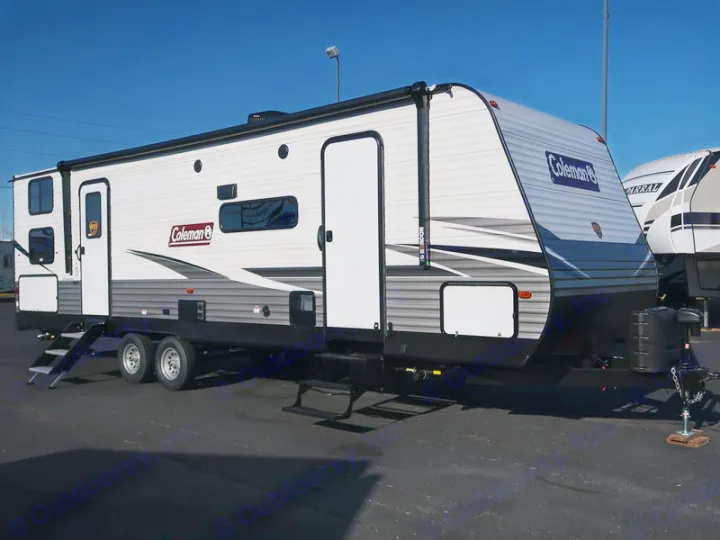 A sleek white & gray Coleman travel trailer, an ideal rv rental for outdoor adventures. Parked under a clear blue sky.. Dutchmen Coleman 2022