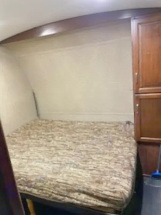 RV rental interior: a comfy bedroom with patterned mattress & dark wood cabinets. Ideal sleeping space.. Keystone Outback 2018