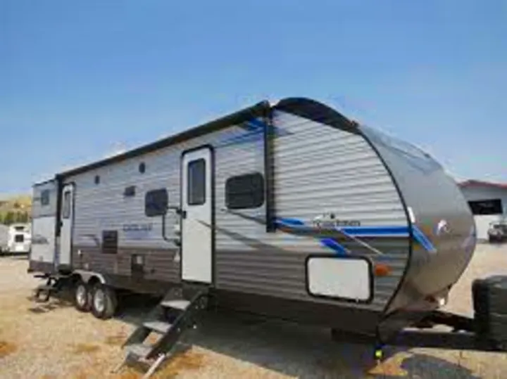 Spacious grey & blue travel trailer, an ideal RV rental. Awning extended, steps down; perfect for camping adventures.. Coachmen Catalina 2022