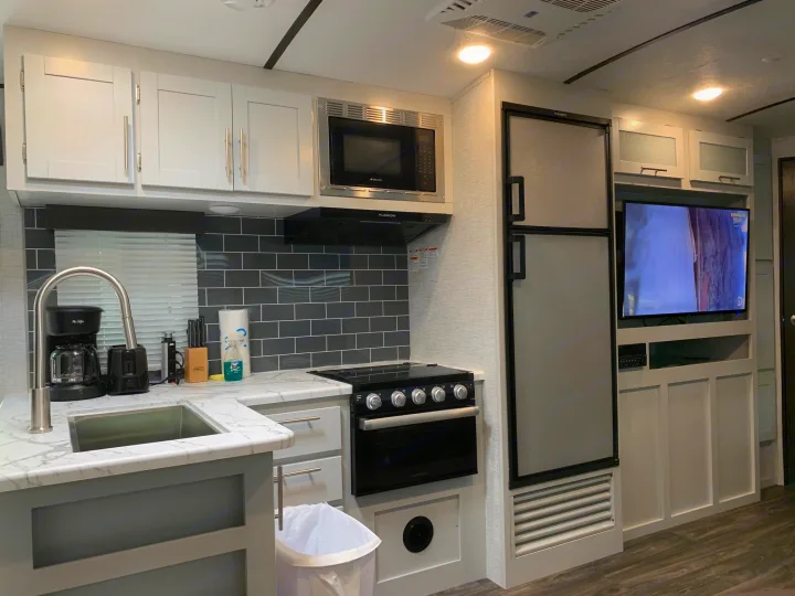 RV rental: Bright, modern interior features a full kitchen with sink, stove, microwave, fridge, and an entertainment TV.. Keystone Bullet 2021