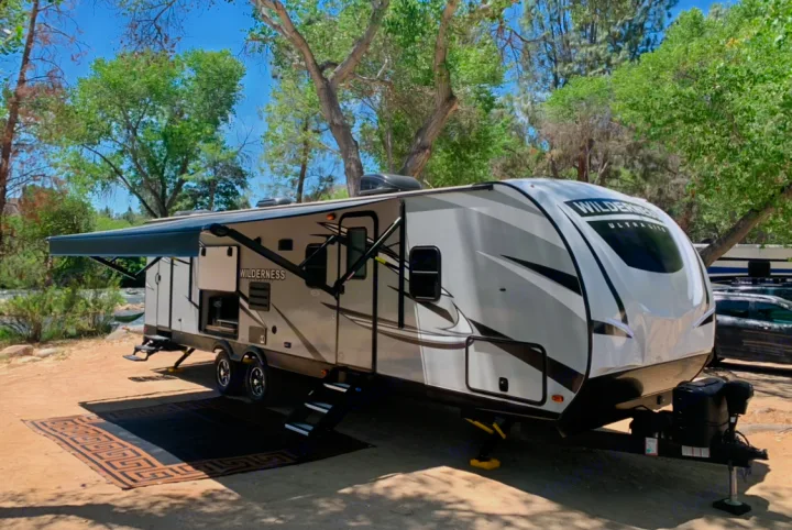 Wilderness Ultra-Lite RV rental at a scenic campsite by the river, ready for outdoor adventure.. Heartland Wilderness 2020