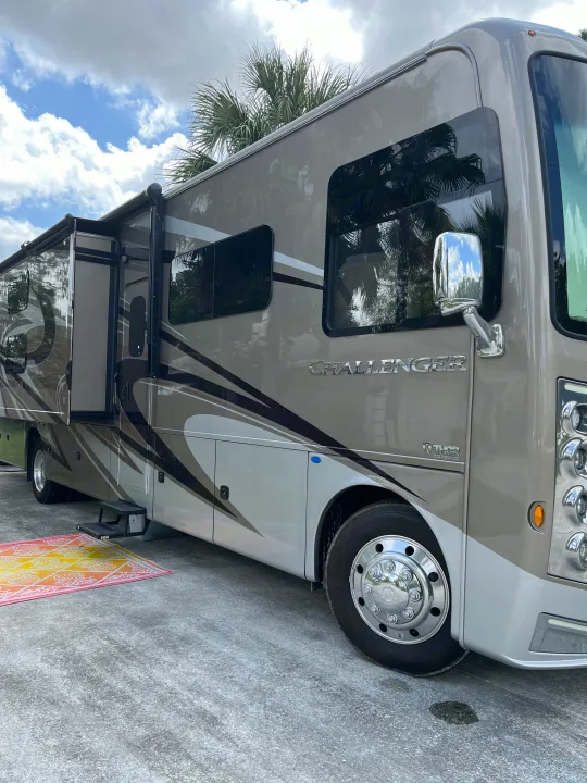 This modern RV rental, a Thor Challenger motorhome, is set up with its slide-out and awning for travel.. Thor Challenger 2021
