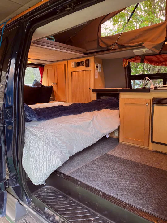 Cozy RV rental interior: pop-top camper with bed, kitchen, and ample storage, perfect for your next adventure.. Pleasure Way Traverse 2003