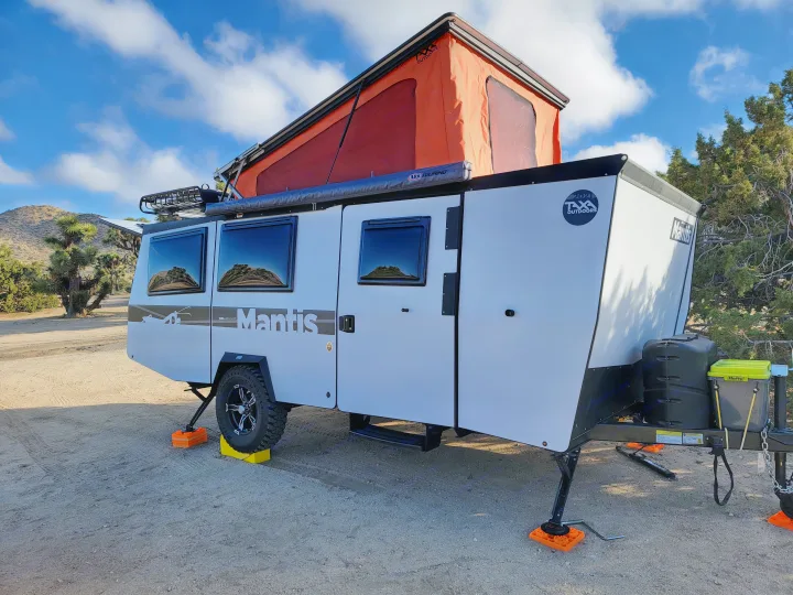 Off-road Taxa Mantis camper rv rental with pop-top tent, set in a desert landscape.. TAXA Habitat Mantis 2021