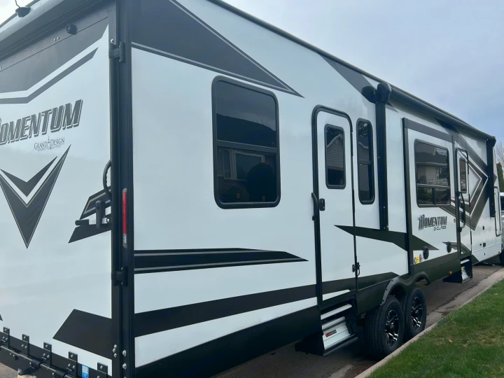 This sleek white and black Momentum toy hauler RV rental is ready for your next camping and outdoor adventure.. Grand Design Momentum 2022