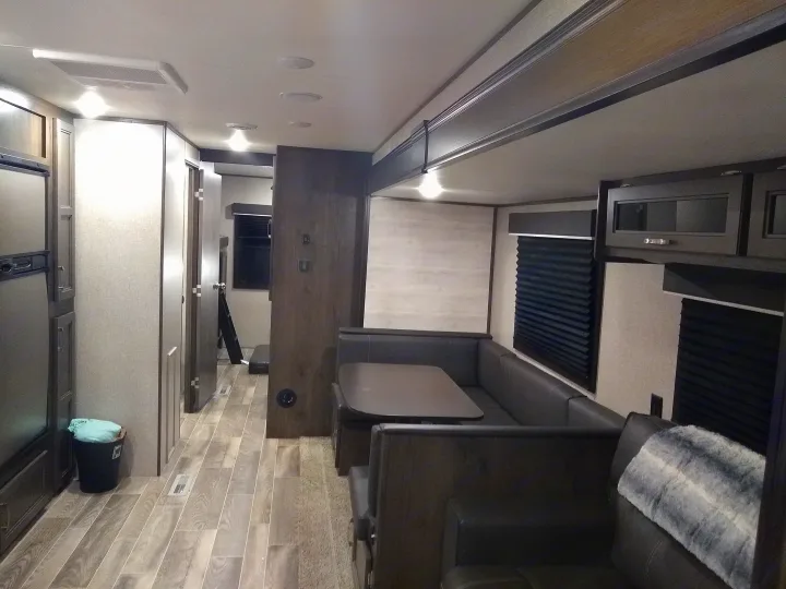 Bright, modern RV rental interior featuring a large dinette, fridge, and hallway leading to bedrooms.. Jayco Jay Flight SLX 2021
