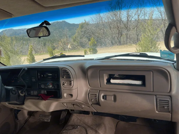 Dashboard view inside an RV rental, showing controls and a mountain landscape through the windshield.. Chevrolet Open Road 1998