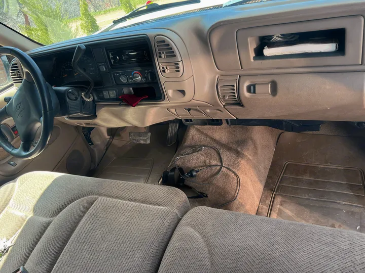 Older model Chevrolet truck/SUV interior, showing dashboard, steering wheel, and cloth seats. Perfect for your next **rv rental** adventure!. Chevrolet Open Road 1998