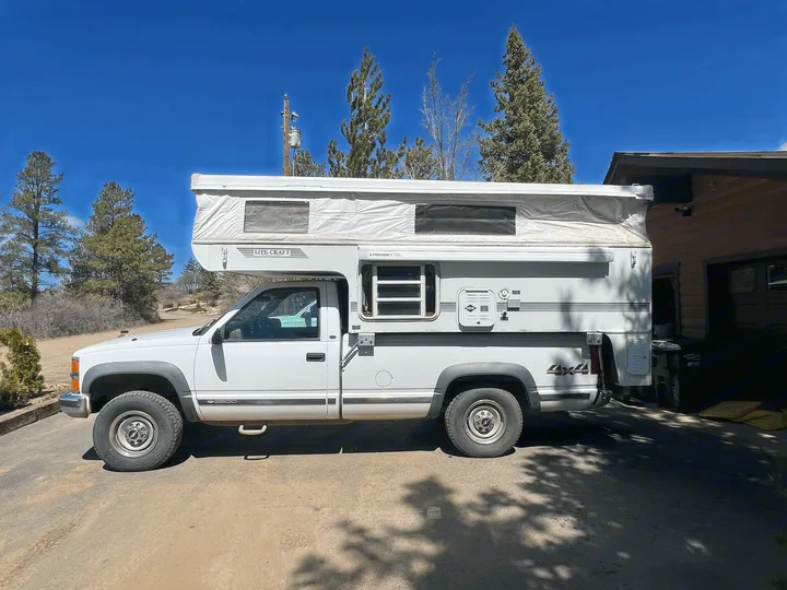 This white pickup truck with a Lite-Craft pop-up truck camper is ideal for your next RV rental adventure.. Chevrolet Open Road 1998