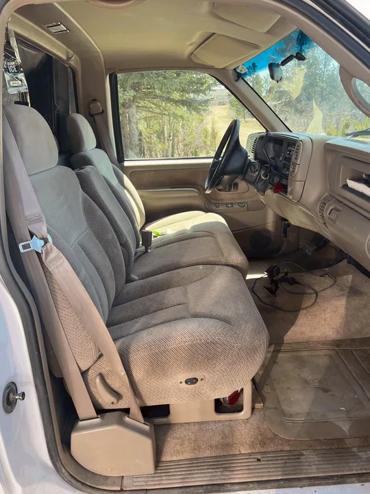 Spacious grey and tan interior of a vehicle, ideal for an RV rental, featuring dashboard, steering wheel, and front seats.. Chevrolet Open Road 1998