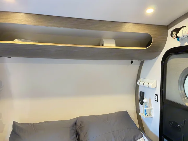 RV rental interior: cozy sleeping area with overhead storage, remote, bottle holder, and fire extinguisher.. Bean Mean Bean 2022