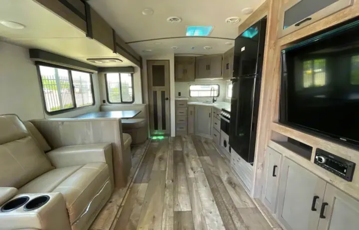 Explore this modern RV rental interior featuring comfortable living space, full kitchen, and dining booth.. Keystone RV Outback Ultra-Lite 2020