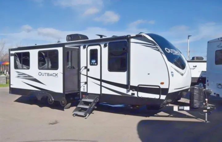 Outback travel trailer, a spacious white and black RV with a slide-out, ready for an rv rental.. Keystone RV Outback Ultra-Lite 2020