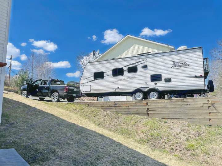 A dark pickup truck hitched to a white Jay Flight travel trailer on a sunny day, ready for an rv rental adventure.. Jayco Jay Flight SLX 2017