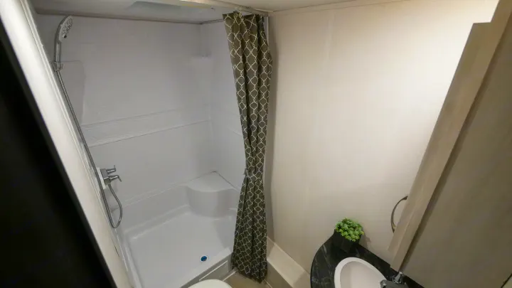 Full RV rental bathroom with clean shower, sink, and toilet. Compact, modern interior for comfortable travel.. Prime Time RV 260BHSLE 2022