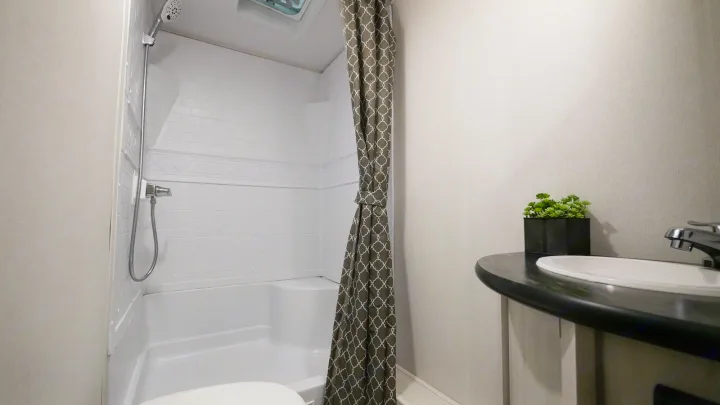 Compact RV rental bathroom with shower, sink, and stylish decor. Perfect for your road trip comfort.. Prime Time RV 260BHSLE 2022