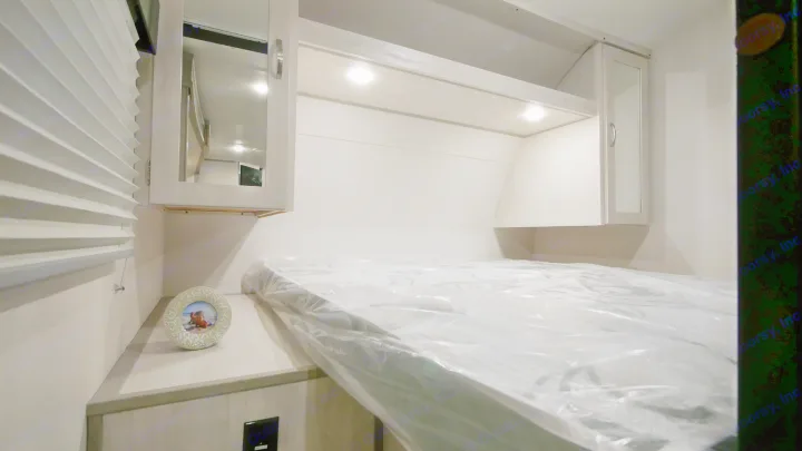 Clean RV rental bedroom with new mattress, overhead cabinets, and lighting. Ready for your next adventure!. Prime Time RV 260BHSLE 2022