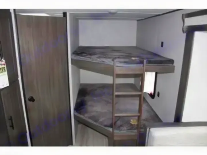 Inside this RV rental: cozy bunk beds with dark grey bedding, a ladder, and a wooden door. Ideal for your next family road trip.. Other Other 2021