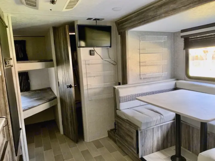 Spacious RV rental interior featuring bunk beds, a dinette, and ample storage for comfortable travel.. Forest River Salem FSX PLATINUM 2020