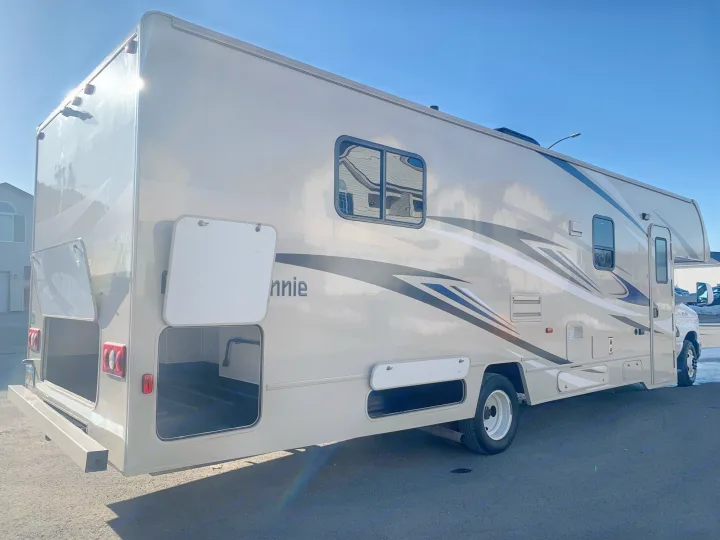 Spacious rv rental with open storage compartments, ready for your next travel adventure under a clear sky.. Winnebago Minnie Winnie 2020