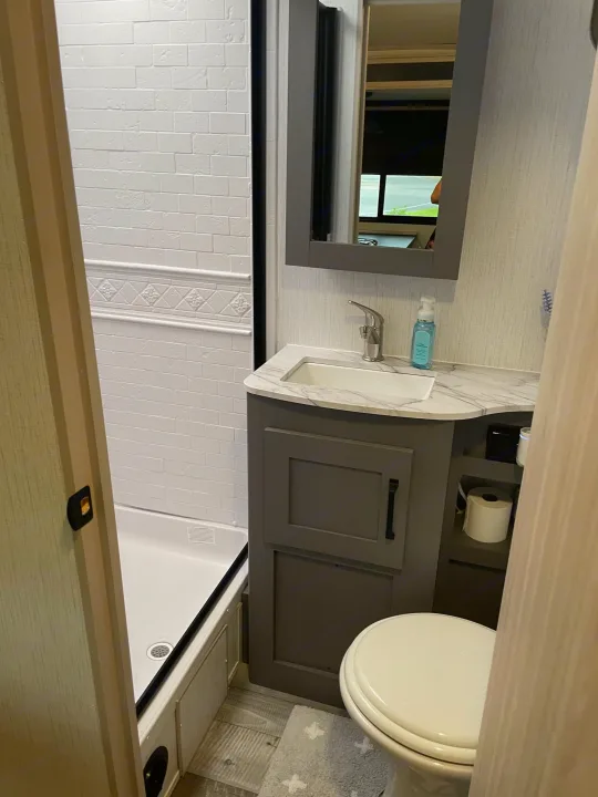 Modern RV rental bathroom with shower, sink vanity, and toilet for a comfortable trip.. Heartland Sundance 294BH 2022