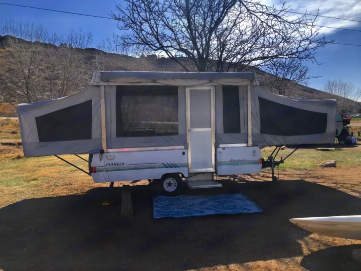 This pop-up camper RV rental is ready for adventure! Enjoy the outdoors with this cozy setup near scenic hills.. Coleman Chesapeake 1993