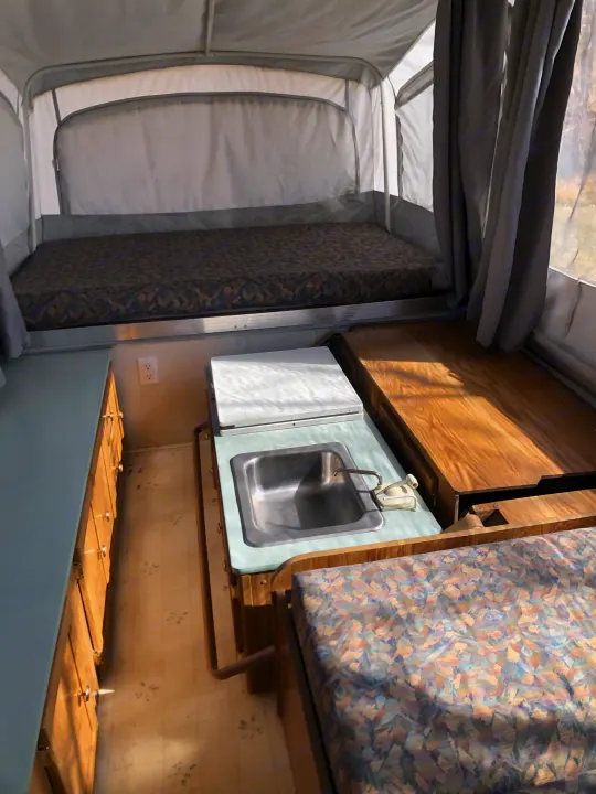 Inside this pop-up RV rental, you'll find cozy beds, a compact kitchen with a sink, and storage cabinets, ready for adventure.. Coleman Chesapeake 1993