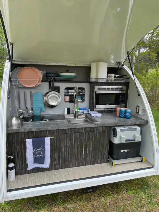 This RV rental's compact outdoor galley features a sink, microwave, fridge, and storage, perfect for camping.. InTech RV InTech RV Trailer 2018