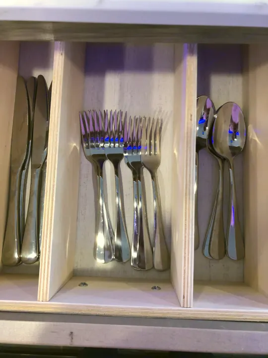 RV rental ready: a tidy wooden drawer organizer holding knives, forks, and spoons for your culinary convenience.. Forest River Cherokee Alpha Wolf 2022