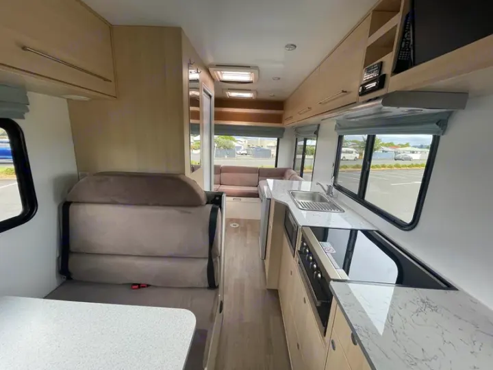 An RV rental's bright interior features a well-equipped kitchen, comfortable seating area, and overhead storage.. Mercedes-Benz Sprinter 2018
