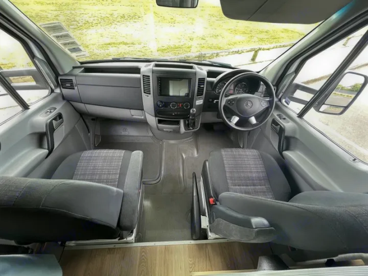 Interior of an RV rental: The spacious cockpit view features driver and passenger seats, dashboard, and steering wheel.. Mercedes-Benz Sprinter 2018