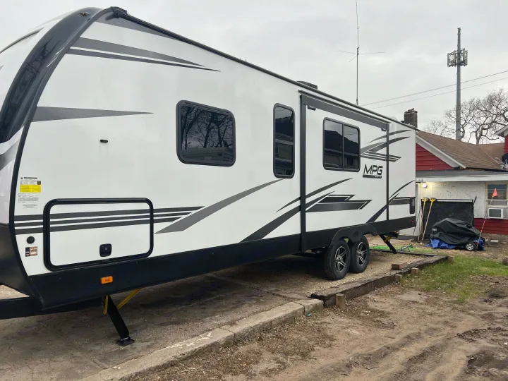 RV rental: Sleek white MPG travel trailer parked on a mixed concrete and dirt lot, ready for your next trip.. Other Other 2021